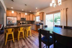 a kitchen with a dining table and yellow chairs at CDA Hideaway 4 bed 3 Bath Modern Mid Term Rental in Hayden