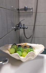 a group of green glass bottles sitting on a bathroom sink at Your Destination in Lixouri
