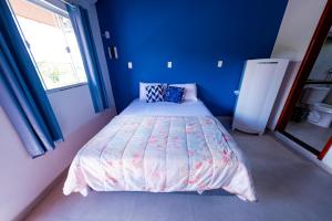 um quarto com uma cama com paredes azuis e uma janela em Flats 2 Locação Penedo RJ em Penedo