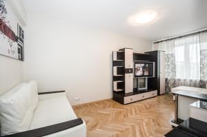 a living room with a white couch and a tv at Nice Flats Belorusskaya in Moscow
