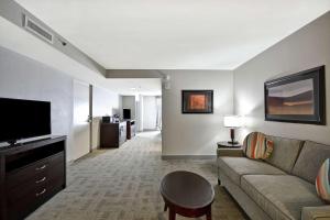 Hilton Garden Inn Toledo / Perrysburg في بيرسبورغ: غرفة معيشة مع أريكة وتلفزيون بشاشة مسطحة
