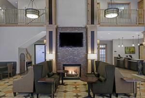 un vestíbulo con chimenea, mesas y sillas en Homewood Suites by Hilton Vancouver / Portland en Vancouver