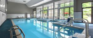 a pool with several tables and chairs in a building at DoubleTree by Hilton Hotel Chicago Wood Dale - Elk Grove in Wood Dale