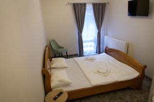 a bedroom with a bed and a chair and a window at Hotel Vegas Negreni in Negreni
