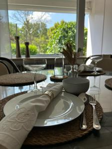 a table with a plate and wine glasses on it at Wohnen am Schloss in Wolfsburg