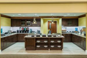 a large kitchen with wooden cabinets and a large island at Homewood Suites by Hilton St. Louis Riverport- Airport West in Maryland Heights