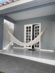 een wit huis met een net op de veranda bij Charlotte House in Canoa Quebrada