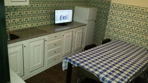 a kitchen with a table and a tv on a counter at Casa do Pico in Câmara de Lobos