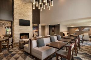 a hotel lobby with a fireplace and tables and chairs at Homewood Suites by Hilton Portland Airport in Portland