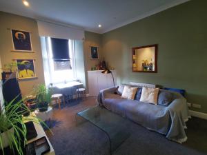 ein Wohnzimmer mit einem Sofa und einem Tisch in der Unterkunft The Haymarket Flat in Edinburgh