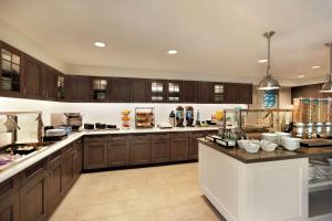 a large kitchen with wooden cabinets and a counter top at Homewood Suites by Hilton Portland Airport in Portland +29 photos