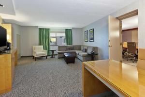 Embassy Suites by Hilton Auburn Hills في أوبورن هيلز: غرفة معيشة بها أريكة وتلفزيون