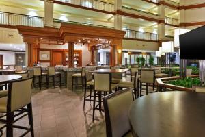 a restaurant with tables and chairs and a bar at Embassy Suites by Hilton Auburn Hills in Auburn Hills