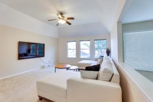 a living room with a white couch and a ceiling fan at Spacious Sugar Land Retreat with Fireplace and Yard in Sugar Land