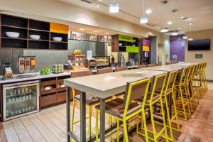 a cafeteria with a large table and yellow chairs at Home2 Suites by Hilton San Antonio Downtown - Riverwalk, TX in San Antonio