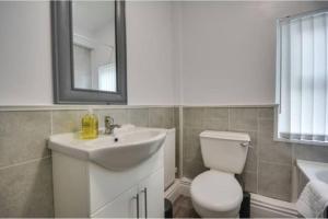 ein Badezimmer mit einem Waschbecken, einem WC und einem Spiegel in der Unterkunft Antonio str Liverpool 8 beds in Liverpool