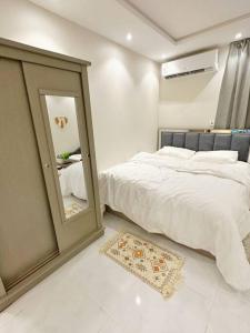 a bedroom with a large bed and a mirror at ستوديو البوليفارد مدخل جانبي h3 in Riyadh