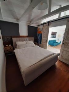 ein Schlafzimmer mit einem großen Bett und einem blauen Sofa in der Unterkunft בשרונה בגליל in Sharona