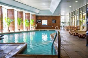 a swimming pool in a hotel lobby with chairs at Hampton Inn Virginia Beach Oceanfront North in Virginia Beach