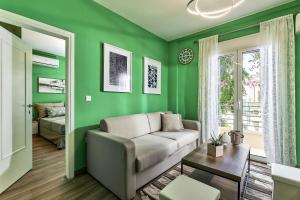 a living room with green walls and a couch at Domenico Homes - City Center in Heraklio