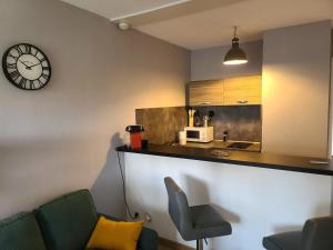 a room with a counter and a clock on the wall at Magnifique Studio 26m2 in Belfort