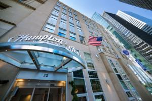 an american flag flying in front of a building at Hampton Inn Manhattan/Downtown- Financial District in New York