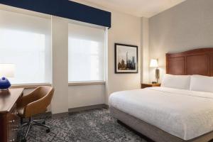 a hotel room with a bed and a desk and window at Hampton Inn Manhattan/Downtown- Financial District in New York