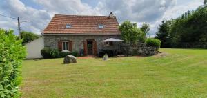 una pequeña casa de piedra con un patio de césped en Maison de vacances La Valessoune en Valessard