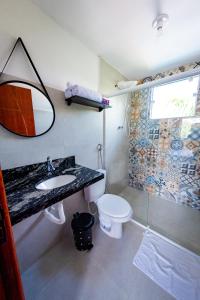 uma casa de banho com um lavatório, um WC e um espelho. em Flats 2 Locação Penedo RJ em Penedo
