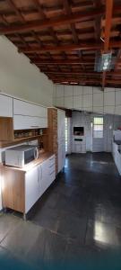 a large kitchen with white appliances in a large room at Sitio Chacara temporada Lindoia Villa Vale in Lindóia