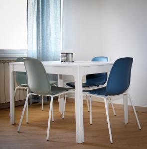 a white table with four chairs around it at Mau Beach House in Lido di Ostia +21 photos