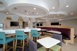 a waiting room with tables and chairs and a tv at Hampton Inn Hopewell Fort Gregg-Adams in Hopewell