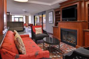 a living room with a red couch and a fireplace at Hampton Inn Norfolk/Virginia Beach in Virginia Beach