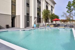a large swimming pool in front of a building at Hampton Inn Norfolk/Virginia Beach in Virginia Beach