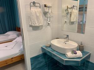 a bathroom with a sink and a bed at VILLA STATHIS in Nea Vrasna