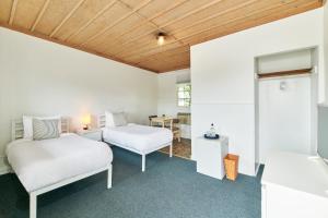 a bedroom with two beds and a desk and a table at The Sunset Montauk in Montauk