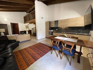a kitchen with a wooden table and blue chairs at S'Abba Druche rooms in Bosa