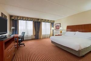 Habitación de hotel con cama, escritorio y TV. en Hilton Garden Inn Washington DC/Greenbelt, en Greenbelt