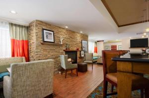 a living room with a fireplace and a stone wall at Hampton Inn Lexington Park in Lexington Park