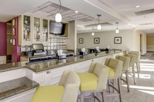 a bar in a waiting room with yellow chairs at Hilton Garden Inn Waldorf in Waldorf