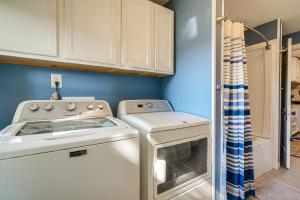 a kitchen with a stove and a washer and dryer at Downtown Russells Point Cottage Near Indian Lake! in Russells Point