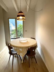 een eetkamer met een tafel en stoelen en een kroonluchter bij Appartamento Ginepro in Pian dei Pradi