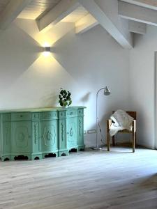een kamer met een groene kast en een stoel bij Appartamento Ginepro in Pian dei Pradi