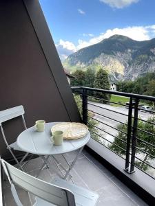 een witte tafel en stoelen op een balkon met uitzicht bij Appartamento Ginepro in Pian dei Pradi