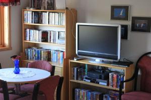 een woonkamer met een tv op een boekenplank met een tafel bij Ildtoppen in Leirpollen