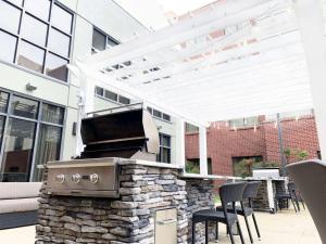 an outdoor patio with a grill and chairs at Homewood Suites by Hilton Richmond - West End / Innsbrook in Broad Meadows