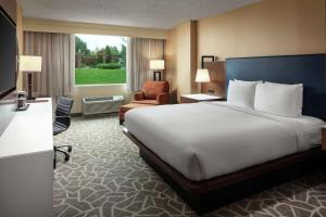安纳波利斯DoubleTree by Hilton Hotel Annapolis的配有一张大床和一把椅子的酒店房间