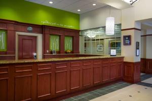 a waiting room with wood cabinets and a green wall at Hilton Garden Inn Detroit Downtown in Detroit