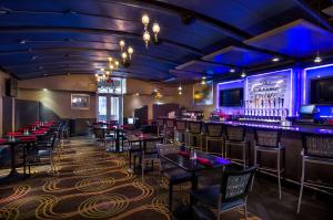 un bar dans un restaurant avec des tables et des chaises dans l'établissement Hilton Garden Inn Detroit Downtown, à Detroit