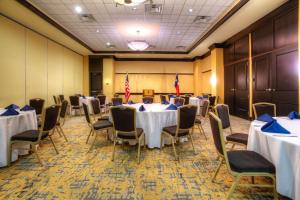 Embassy Suites by Hilton Laredo في لاريدو: قاعة اجتماعات مع طاولات وكراسي واعلام